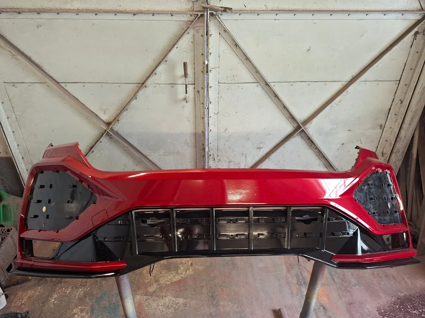 Front bumper freshly resprayed in a deep gloss red after repair